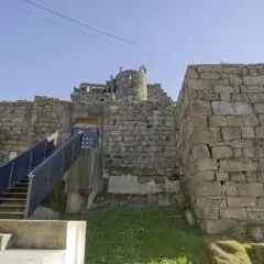 El imponente castillo de Ribadavia, con sus muros de piedra y una escalera metálica que invita a explorar su historia.