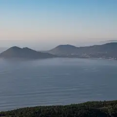 Vista panorámica de la costa gallega con el monte Enxa destacando sobre el mar azul.