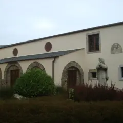 Fachada del convento de Santa Clara en Ribadeo, con arcos de piedra, ventanas y una estatua de monja.