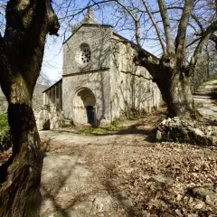 Antiguo monasterio Santa Cristina, rodeado de árboles desnudos y hojas secas. Un camino serpentea hacia la entrada principal.