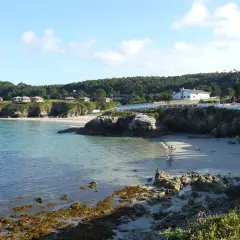 La serena playa o cantiño de Burela, con casas en la colina y aguas cristalinas.