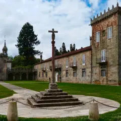 Pazos en Galicia: un cruceiro se alza en el patio de un complejo señorial con torreón y capilla.