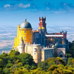 El Pazo da Pena, un palacio de cuento de hadas con cúpulas y torres coloridas, se alza majestuoso sobre una colina verde.
