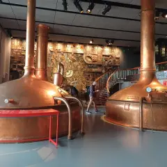 Interior del museo Estrella Galicia con grandes cubas de cobre y un mural histórico.