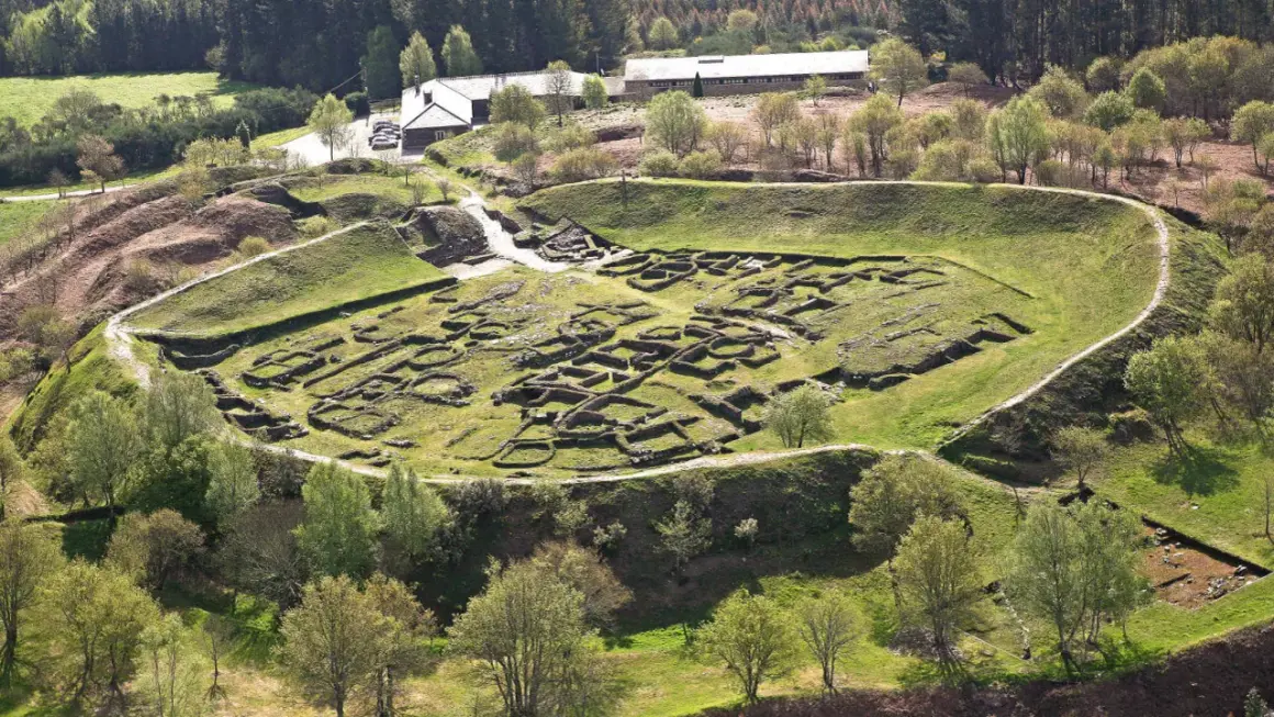Vista aérea del castro de Viladonga, con sus murallas y restos de edificaciones de piedra cubiertos de hierba.
