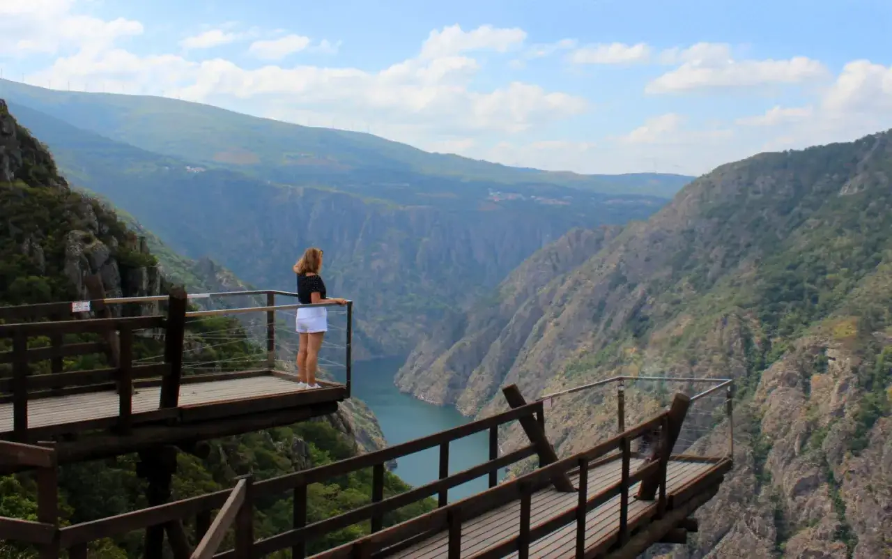 Mujer en el mirador de Matacas, contemplando el cañón y el río. El paisaje montañoso se extiende hasta el horizonte.