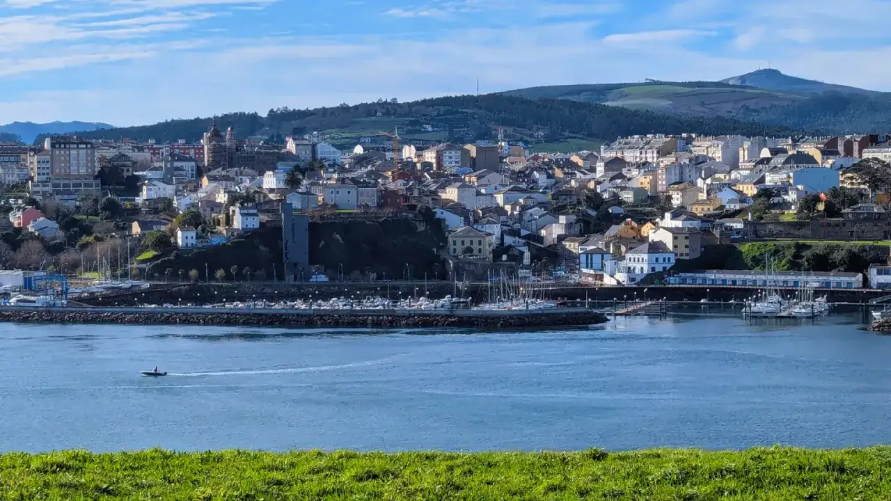 Vista del mirador Ribadeo con el puerto deportivo, barcos y la ciudad al fondo bajo un cielo azul.