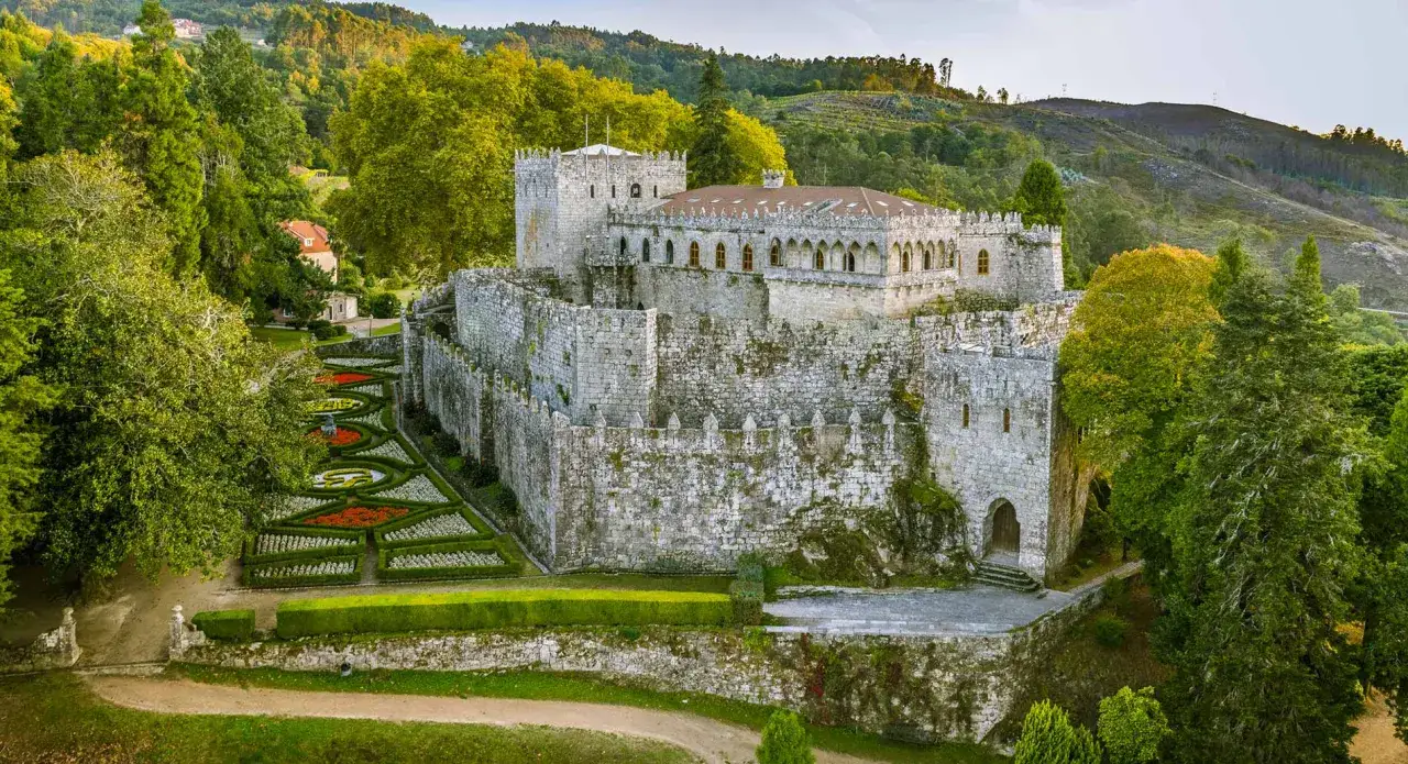 El castillo de Sotomayor, con sus imponentes murallas de piedra, se alza majestuoso rodeado de exuberante vegetación y jardines ornamentales.